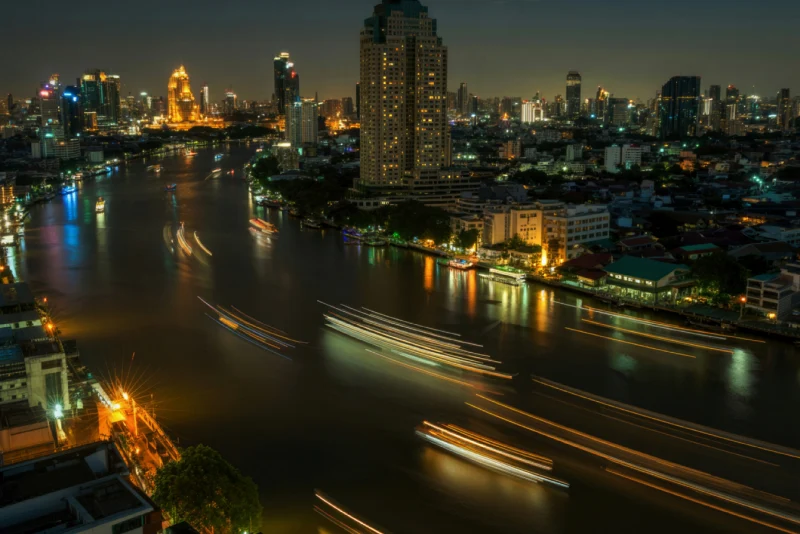 Bangkok Chao Phraya River and illuminated cityscape at night reflecting the vibrant financial services and banking environment for American expats in Thailand