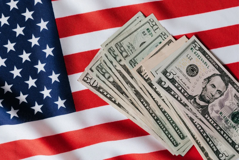 US dollar bills spread on an American flag representing tax-efficient wealth strategies for American expats leveraging the US/Thailand tax treaty