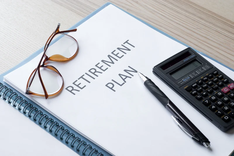 Retirement plan document with reading glasses and calculator representing strategic retirement planning for American expats in Thailand
